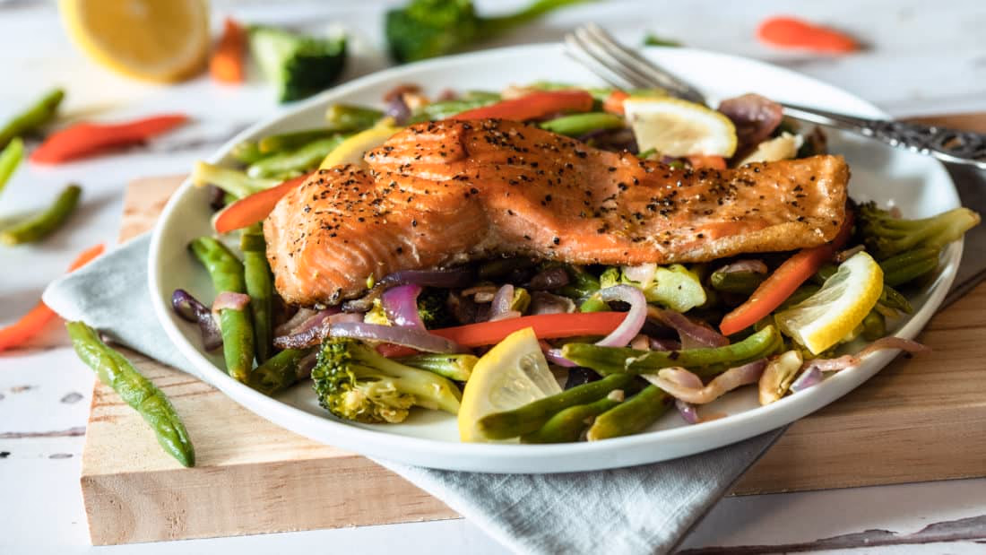 Ovnsbakt ørret på seng av grønnsaker